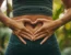 Female torso with hands placed in a heart shape over stomach. Implies she has a healthy gut.